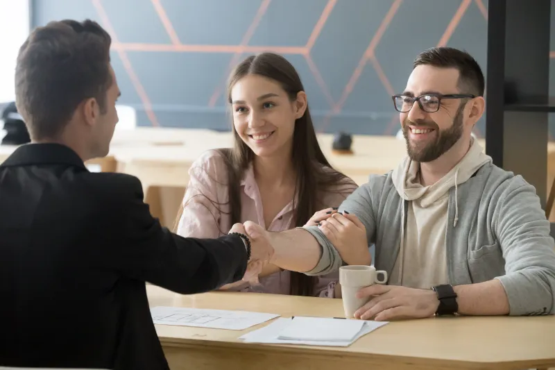 Couple Shaking Hands With Mortgage Professional